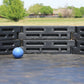 Close-up of a blue gaga ball inside a black modular gaga pit on an outdoor play surface by Castle Sports.
